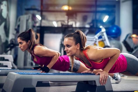 Premium Photo Two Womans In A Gym Doing Push Ups On A Stepper Strong