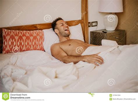 Shirtless Male Model Lying Alone On His Bed In His Bedroomcarefree Guy
