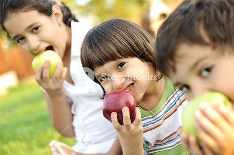 Small Group Of Children Eating Apples Together Royalty Free Stock Image