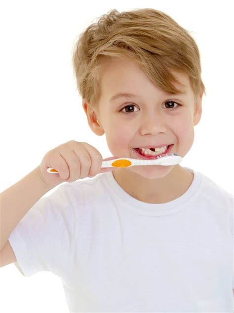 A Little Boy Is Brushing His Teeth With A Toothbrush Stock Photo