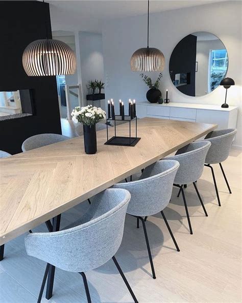 A Dining Room Table With Chairs And Candles On It In Front Of A Large