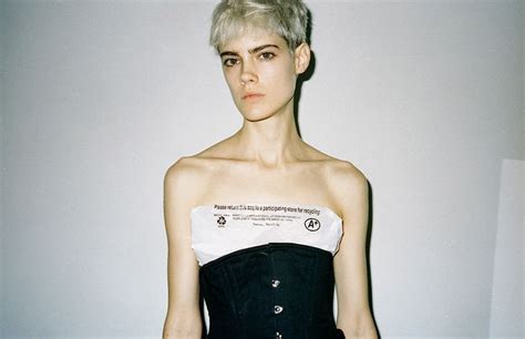 A Woman With Short White Hair Wearing A Black And White Strapless Corset