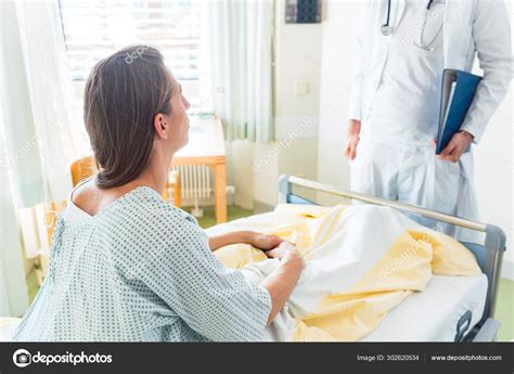 Doctor Seeing Patient In Hospital — Stock Photo © Kzenon 302620534