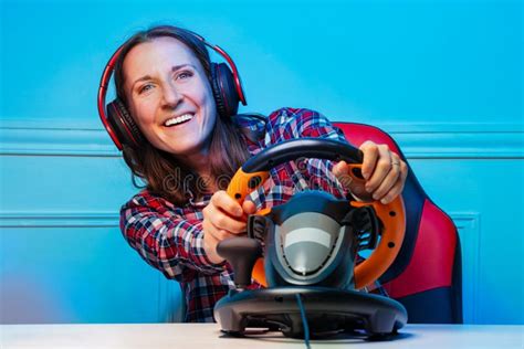 Gamer Woman In Headphones Playing Race Game With Steering Wheel Stock
