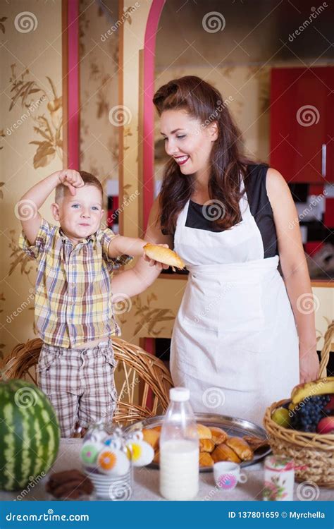 Мать и сын в кухне с печеньями и другой едой Стоковое Изображение изображение насчитывающей