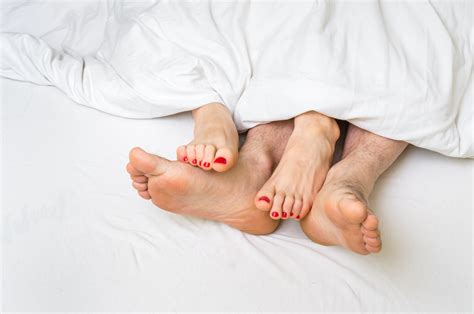 Feet Of A Couple In Bed Under The Blanket Cup