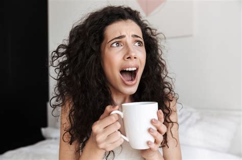 Primer Retrato De Mujer Sorprendida O Asustada Con El Pelo Largo Y Rizado Sentado En La Cama Con