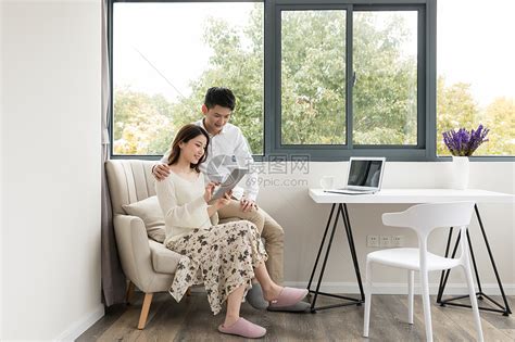 年轻夫妻幸福地坐在沙发上看平板电脑高清图片下载 正版图片500816243 摄图网