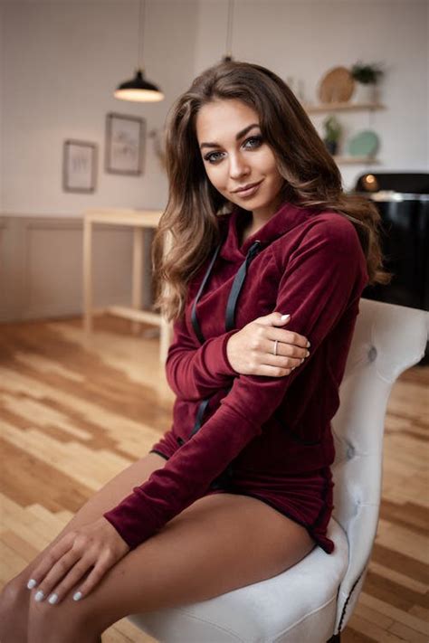 Beautiful woman sitting on cozy chair in studio · Free Stock Photo