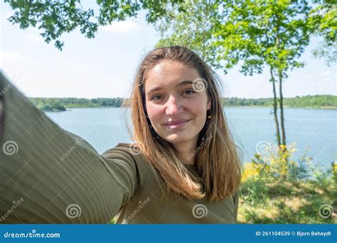 Beautiful Young Brunette Caucasian Woman Taking A Selfie With Smartphone Outdoors On A Forest