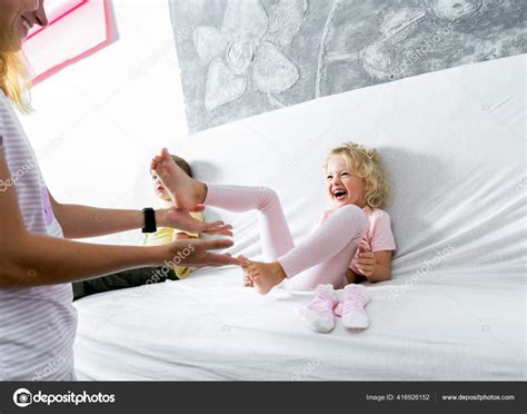 Mom Tickles Her Little Daughters Feet The Girl Laughs Merrily Stock