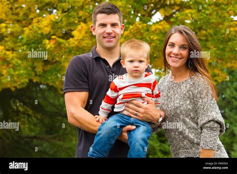 A Husband And Wife Have Their First Child And Pose For A Portrait With