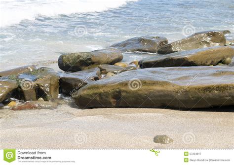 Waves Approaching Sandy Beach With Large Boulders Stock Image Image
