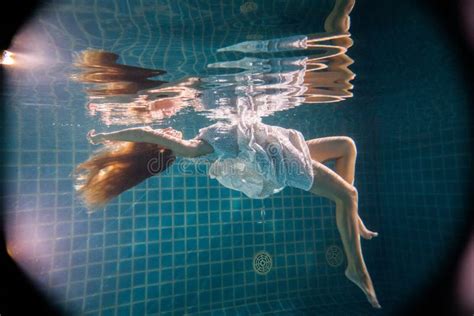 Beautiful Woman Posing Underwater On The Chair In White Dress Stock