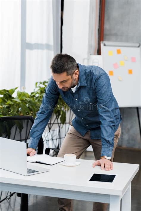 Handsome Businessman Leaning On Table And Looking At Table Stock Image