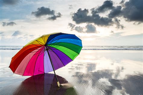 Abstract Multi Colored Rainbow Umbrella On The Beach At Sunset Stock