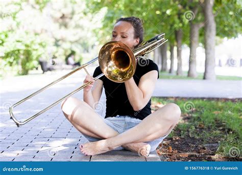 Girl Learning To Play Trombone Girl Plays Sitting On The Plates Of A
