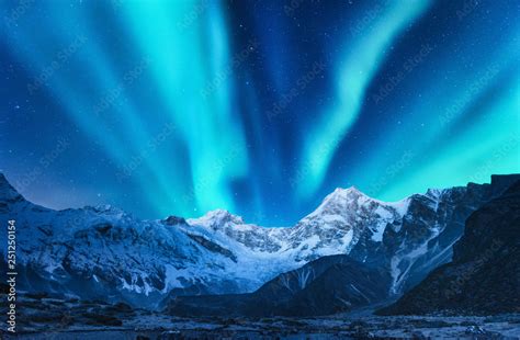 Aurora Borealis Above The Snow Covered Mountain Range In Europe