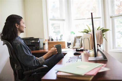 Woman Working On A Desk Top Computer In Her Home Office Stock Photo