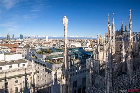 Milan Skyline From The Top Of The Duomo With Alps In The Background