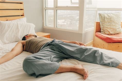 Elevated View Of A Happy Man Lying On Bed With Pillow Free Photo