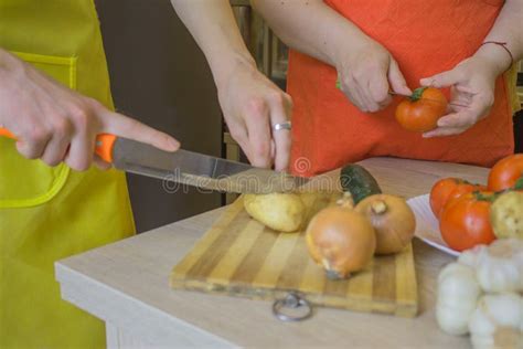 Woman`s Hands Cooking Healthy Meal In The Kitchen Behind Fresh Vegetables Cropped Image Of
