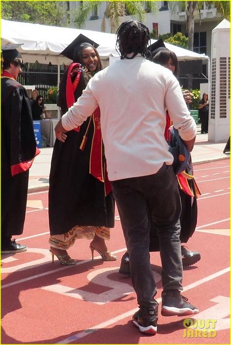 People In Graduation Caps And Gowns Are Walking On The Red Carpet With