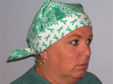 A Woman Wearing A Green And White Bandana With Scissors On It S Head