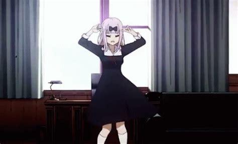 An Anime Girl Standing In Front Of A Window With Her Hands On Her Head And Arms Behind Her Head