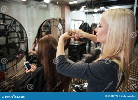 Female Hairdresser Cutting Hair Of Woman Client At Beauty Salon Stock