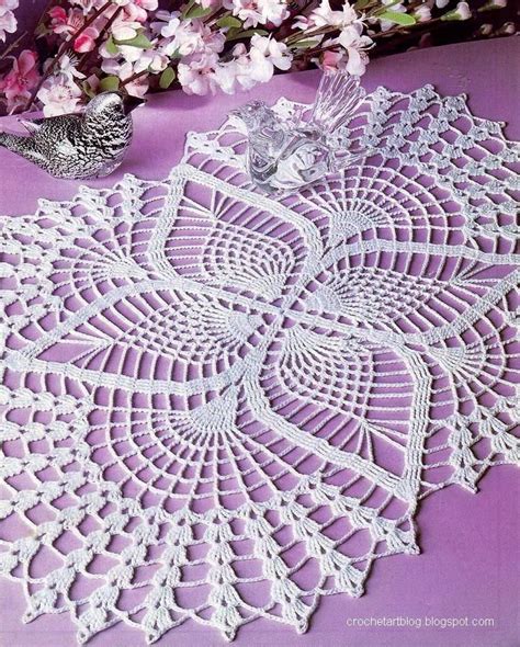 An Image Of A Doily On A Table With Flowers In The Background And A