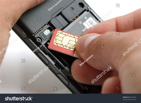 Inserting A Sim Card Into The Back Of A Mobile Phone Stock Photo