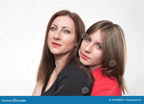 portrait of mother and daughter looking at camera mom in black t shirt and teenager in red
