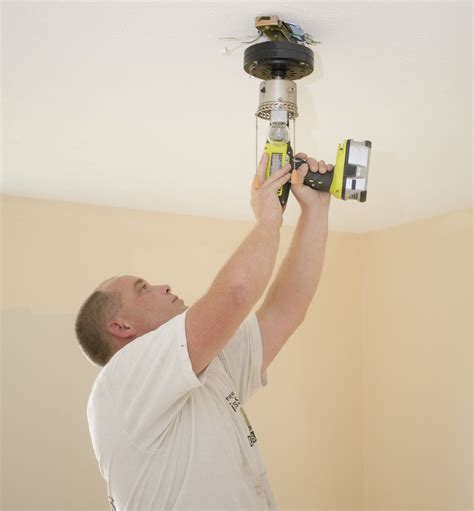 Man Installing Ceiling Light81006151 Fabby Blog