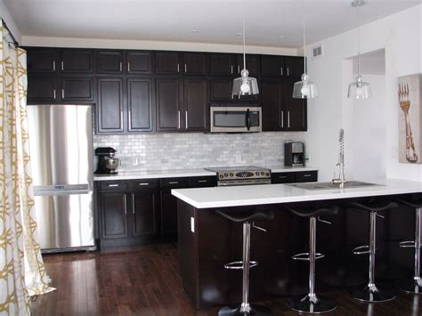 Brown granite countertops also take away the starkness of white kitchen cabinets and highlights the warmth of a space. Kitchen with dark cabinets and white quartz counters ...