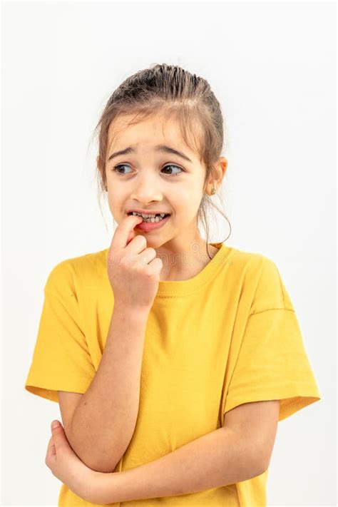 Scared And Anxious Girl Biting Her Fingernails On A White Background