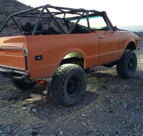 An Orange Truck Parked On Top Of A Rocky Hill