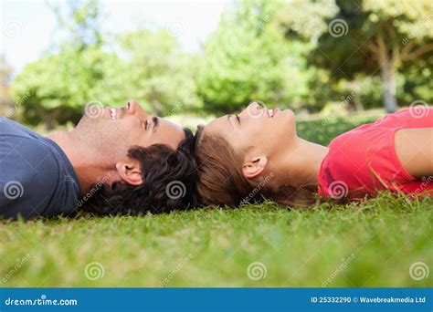 Two Friends Looking Upwards While Lying Head To Head Stock Photo