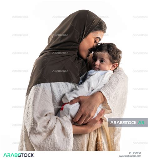 بورتريه لأم عربية خليجية سعودية تحمل طفلها الرضيع بسعادة وحنان، إيماءات تدل الحب والأمان، مفهوم