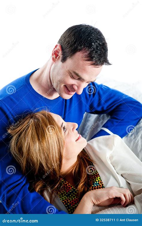 Young Couple Relaxing And Cuddling Together On The Sofa Stock Image