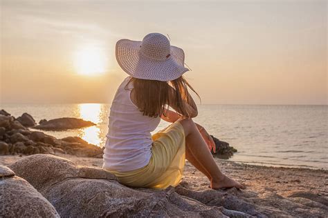 Woman Sitting On The Beach At Sunset By Stocksy Contributor Mosuno Stocksy