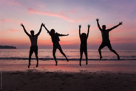 Four Friends Jumping Together At The Beach By Jovo Jovanovic