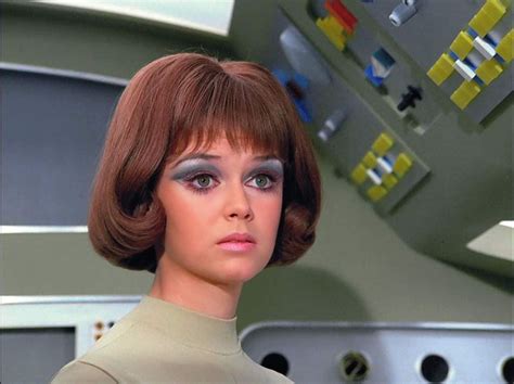 A Woman In A Star Trek Uniform Looks Into The Distance With Her Eyes