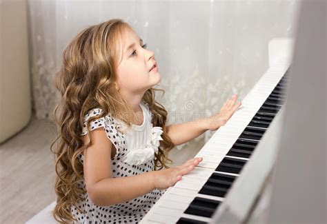 Beautiful Blond Little Girl Playing Piano Stock Photo