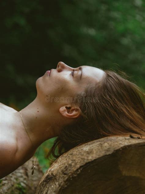 Side Profile Of A Caucasian Woman Laying Over Tree Trunk Looking Straight Nature Scene Stock