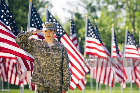 American Female Soldier Saluting In A Field Of American Flags High Res