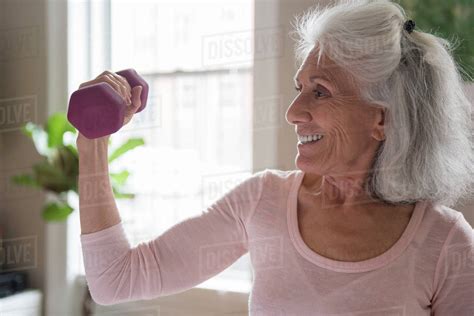 Smiling Older Woman Lifting Weights Stock Photo Dissolve