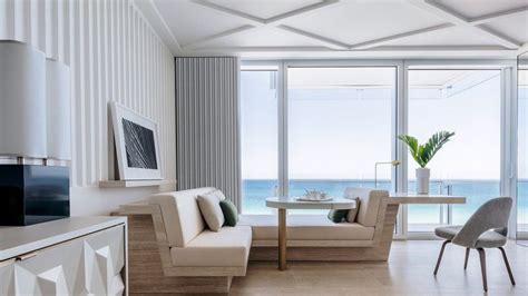 A Living Room Filled With Furniture Next To An Ocean Side Wall Mounted