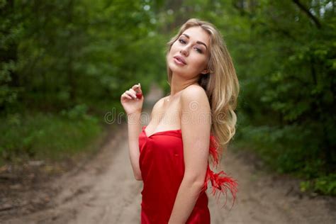 Beautiful Young Long Haired Blonde In A Red Dress Posing On The Road In