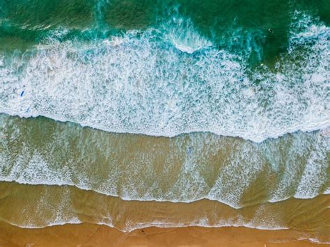 Ocean Beach Aerial Top Down View With Blue Water Waves With Foam And